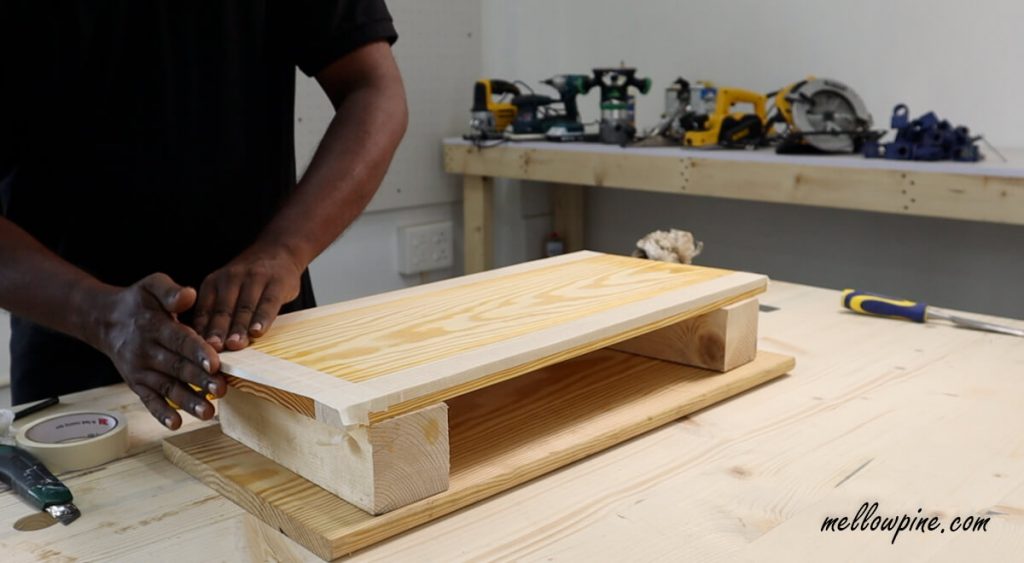 fixing painter's tape on the teak oil board