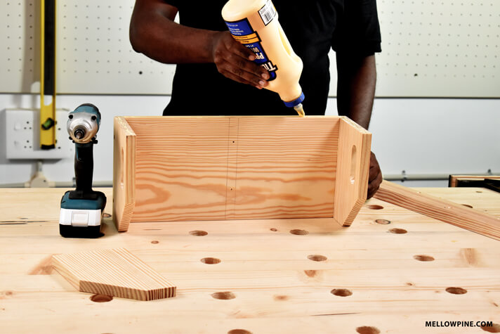 applying glue for fixing the back piece of the bin