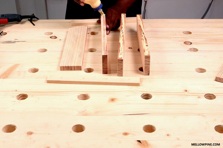 Applying glue on the base pieces before joining them using the bracing piece at the back