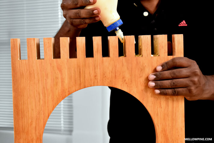 Applying glue in the slots of the legs before fixing the slats inside