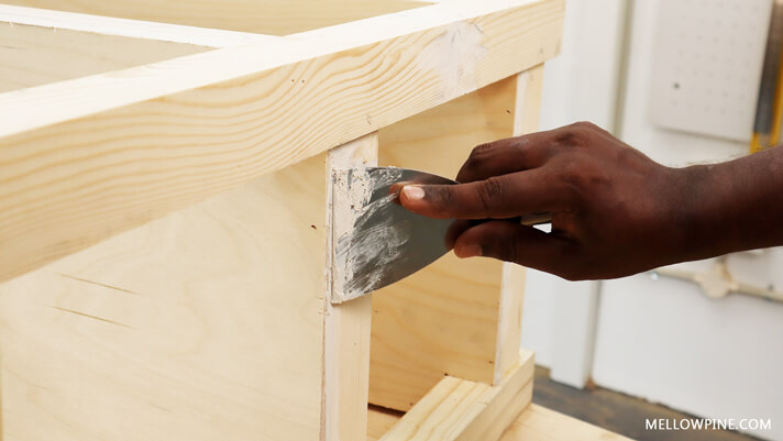 applying wood filler on the edges of the plywood