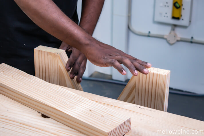Applying wood glue before fixing the frame to the base piece