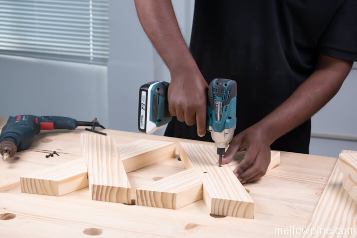 Screwing the X brace pieces together using wood screws