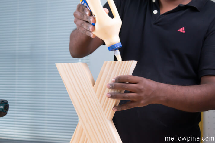 Applying glue before joining the X brace piece to the base piece