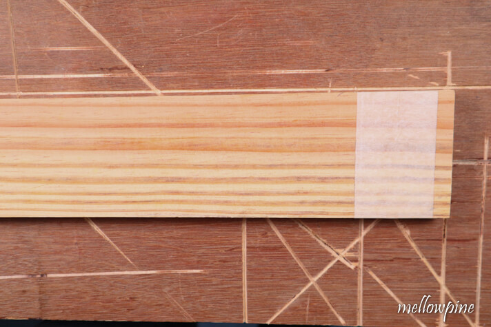 fixing masking tape on the wood to be cut