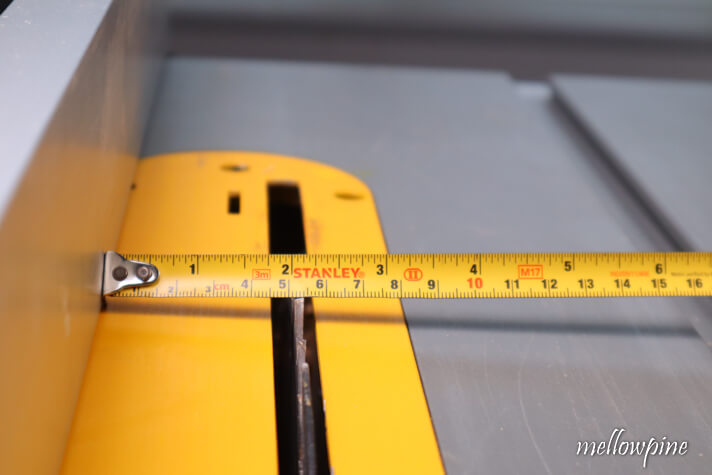 setting the rip fence by measuring with tape