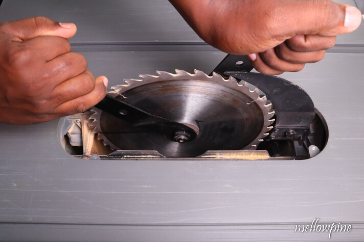 unlocking the blade of the table saw using two wrenches