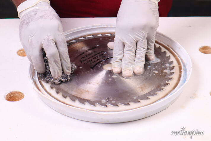 scrubbing the other side of table saw blade with steel wool 