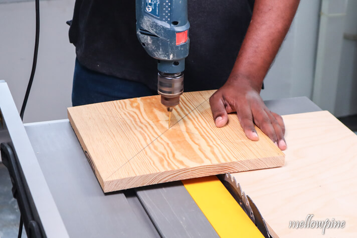 drilling pilot holes for fixing the wooden board to the jig