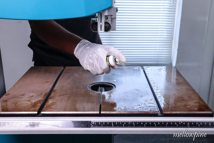 spraying WD-40 on the band saw table