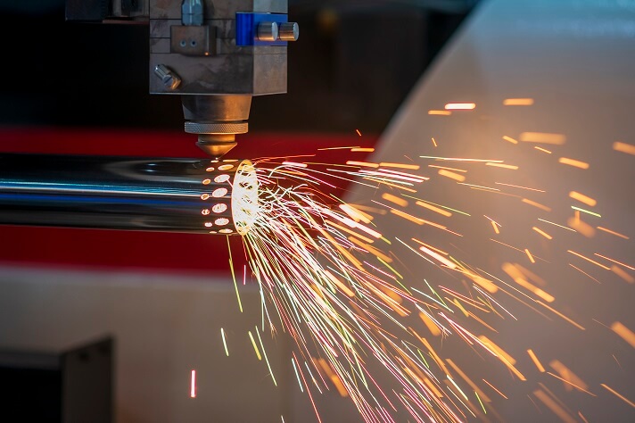 A fiber laser cutter working on a stainless steel pipe