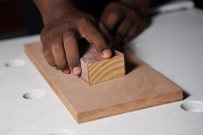 Sanding the workpiece to remove any surface irregularities