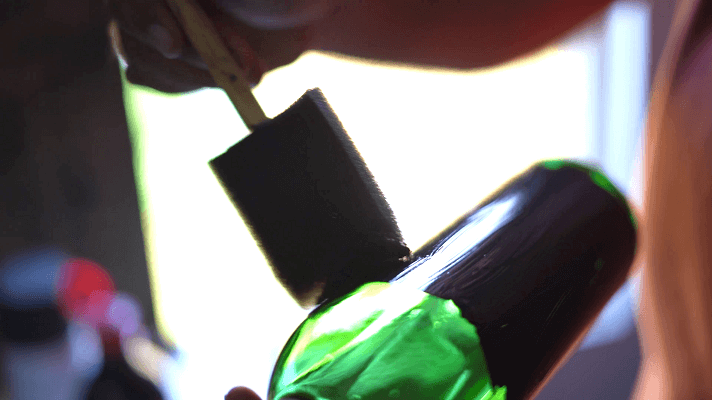 Painting wine bottle surface with a sponge brush