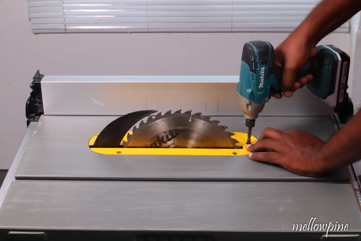 fixing the throat plate back into the table saw